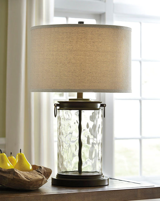 Tailynn - Clear / Bronze Finish - Glass Table Lamp - Premium Table Lamps from Signature Design by Ashley® - Just $138! Shop now at Furniture Wholesale Plus  We are the best furniture store in Nashville, Hendersonville, Goodlettsville, Madison, Antioch, Mount Juliet, Lebanon, Gallatin, Springfield, Murfreesboro, Franklin, Brentwood
