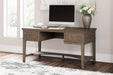 Janismore Home Office Storage Leg Desk - Premium Desk from Ashley Furniture - Just $579.20! Shop now at Furniture Wholesale Plus  We are the best furniture store in Nashville, Hendersonville, Goodlettsville, Madison, Antioch, Mount Juliet, Lebanon, Gallatin, Springfield, Murfreesboro, Franklin, Brentwood